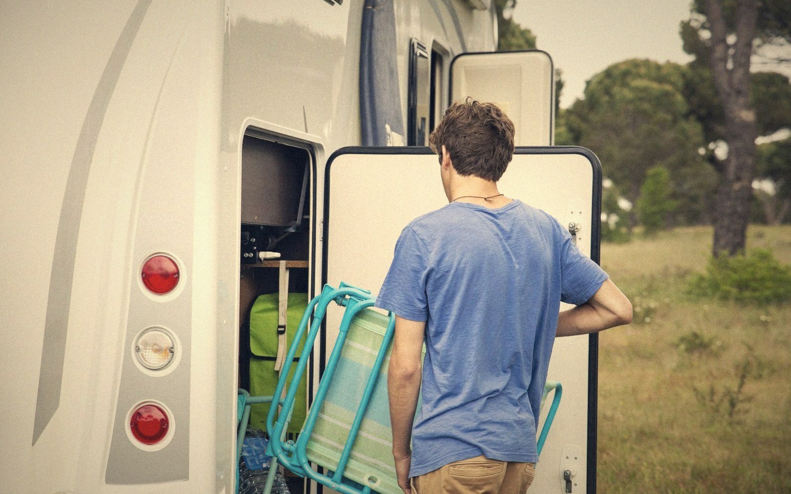 Packing up folding chairs beside a car